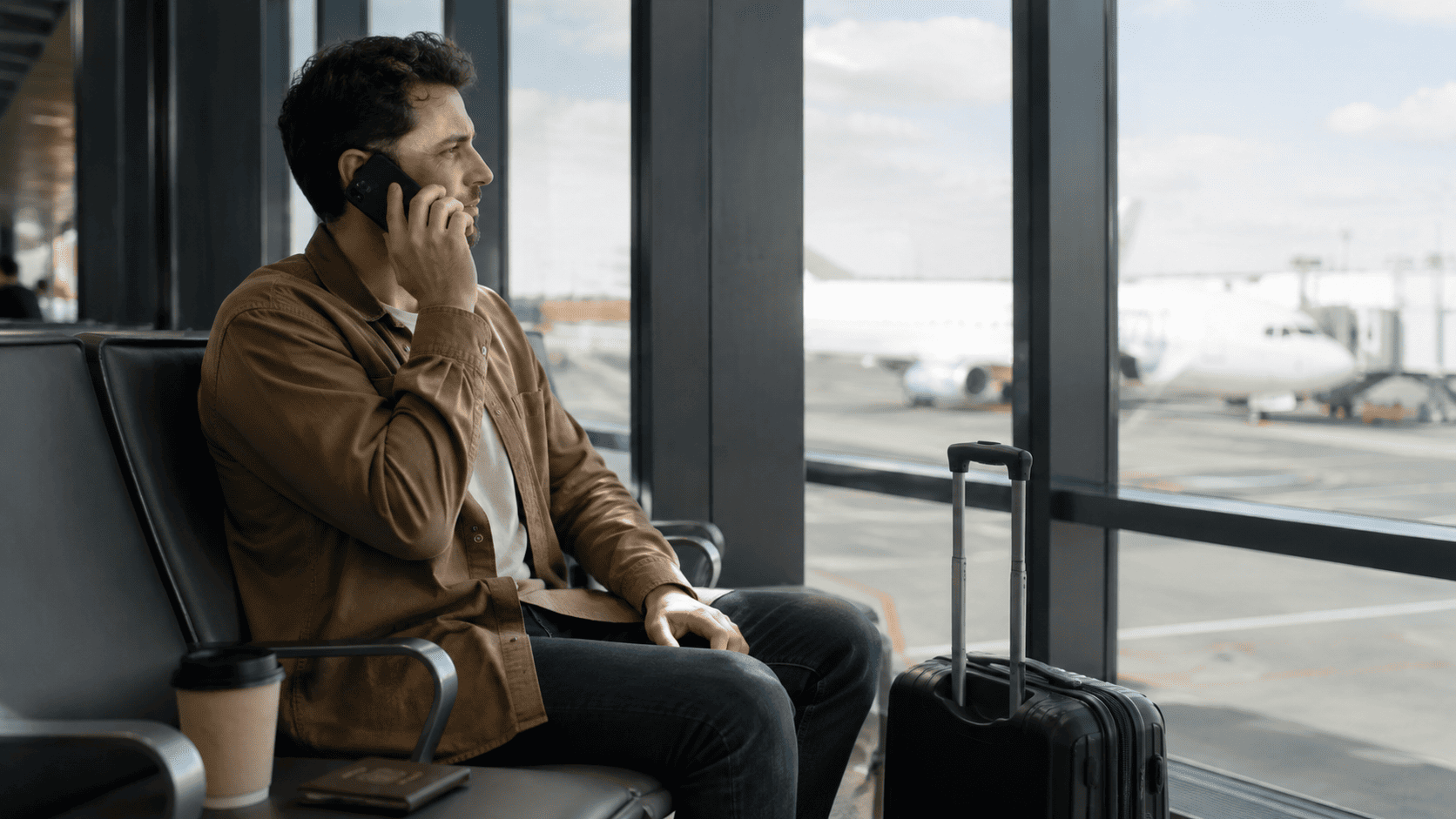 Traveler making a phone call while waiting at an airport gate