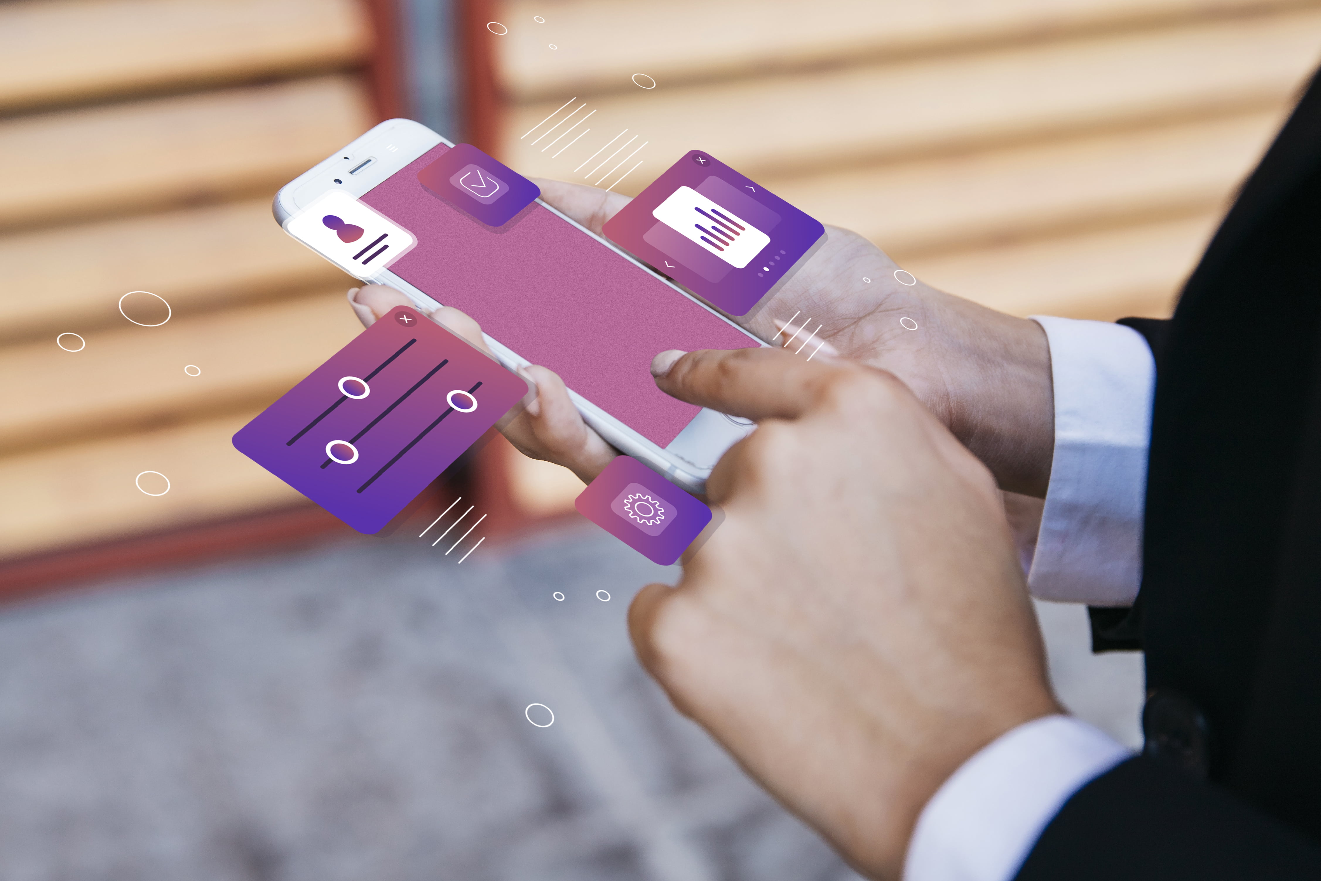 A pair of hands holds a smartphone. The phone's screen is blank, but various holographic, purple-hued user interface elements float around it, including an icon of a person, a graph, a settings gear, and an audio mixer.