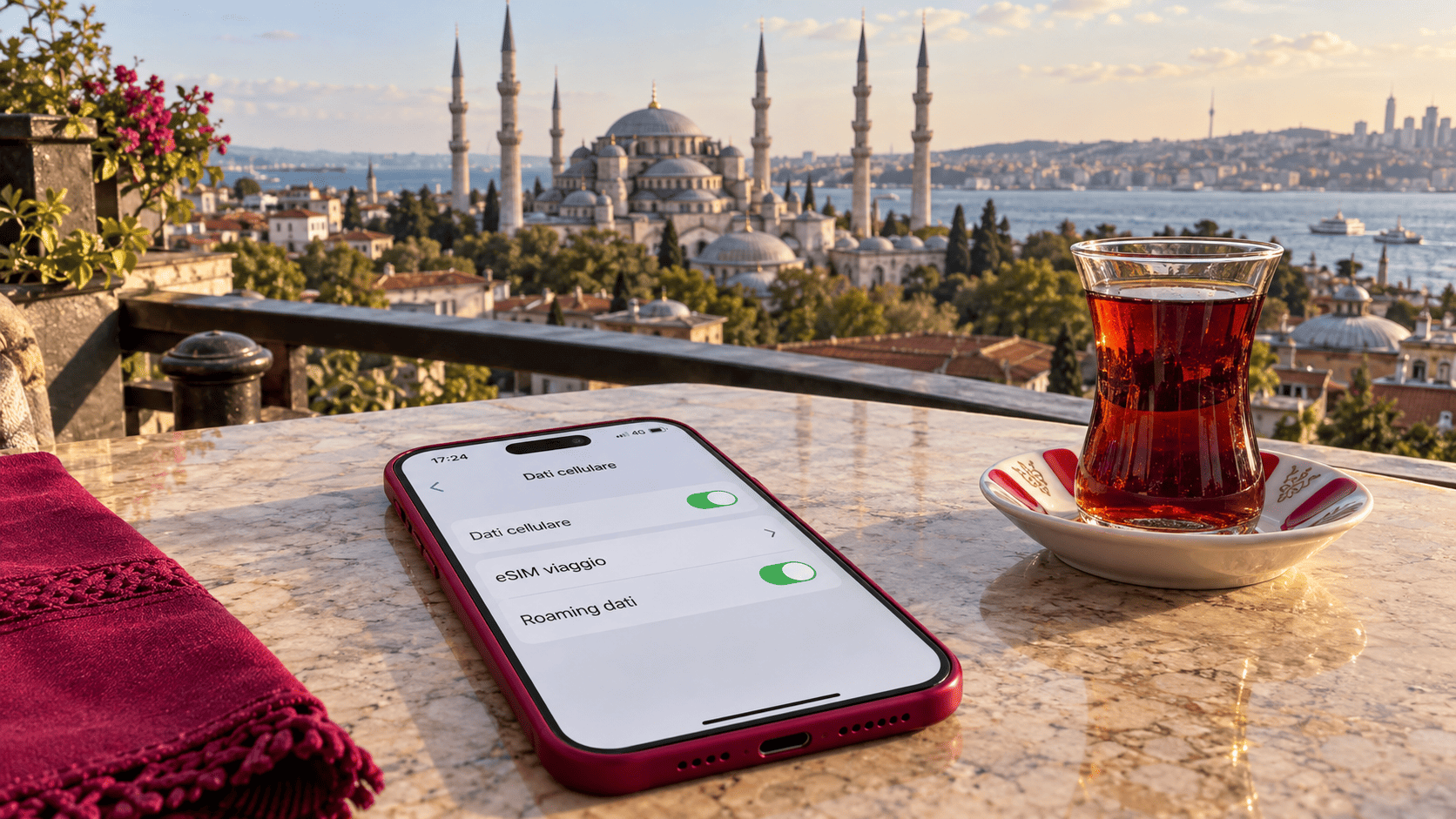 Smartphone con eSIM da viaggio su un tavolo a Istanbul, con tè turco e la Moschea Blu sullo sfondo.