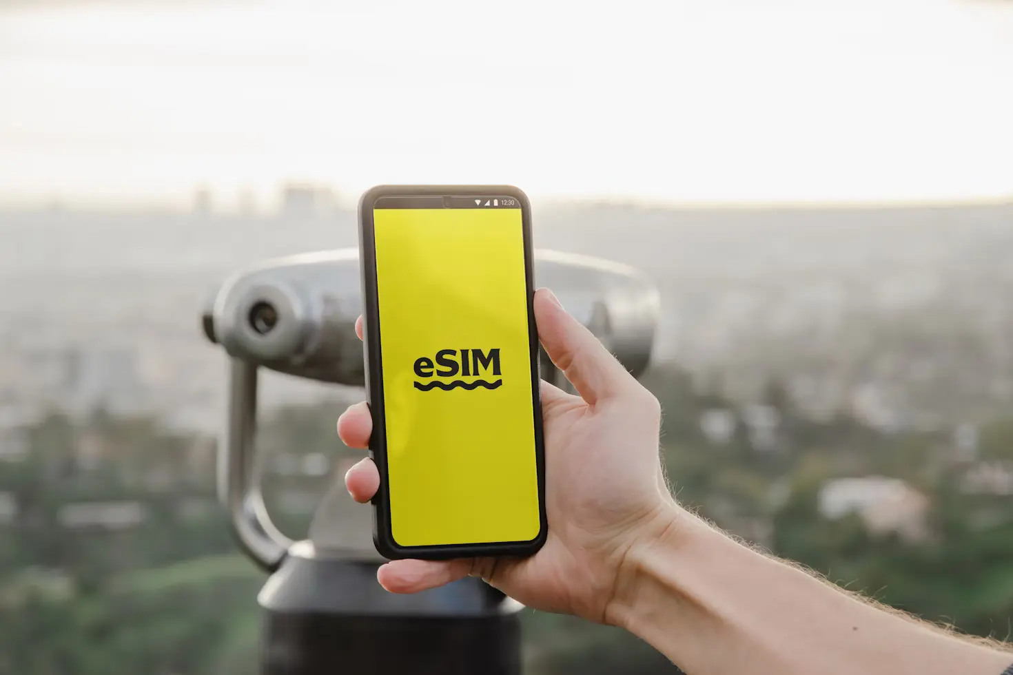 A person holding up a cell phone with a logo in it