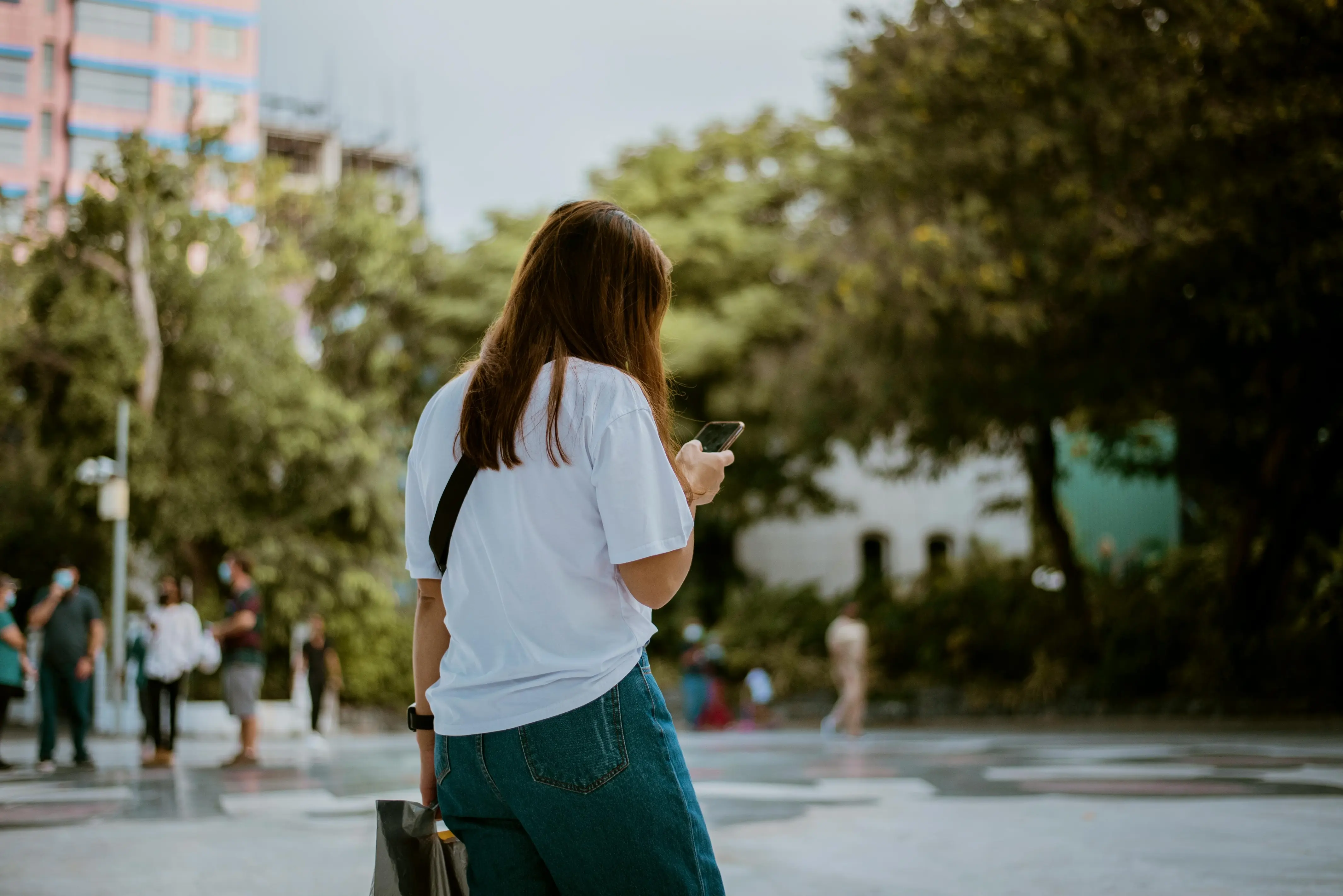 Woman in white shirt holding a cell phone